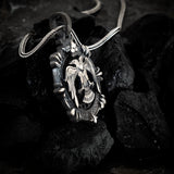 Silver pendant with eagle design on a dark stone surface