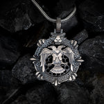 Silver pendant with an eagle design on a dark stone background