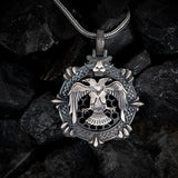 Silver pendant with an eagle design on a dark stone background
